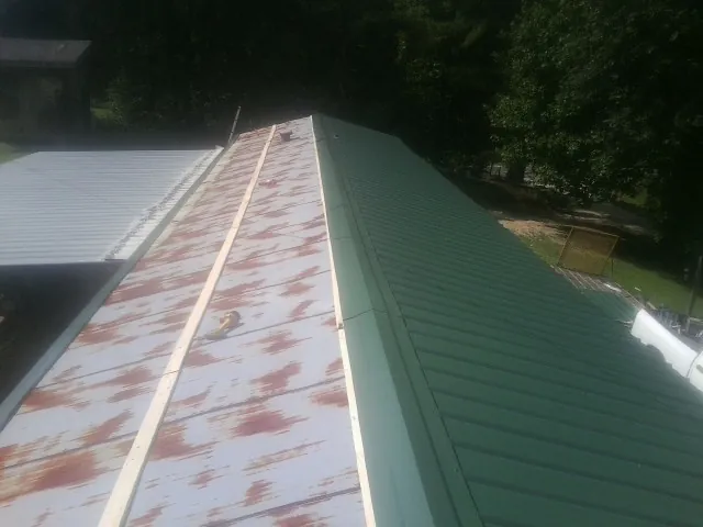 Old rusted panels beside newly installed green metal roofing — Wind Damage Roof Repair by Roofing Brothers in Lindsay